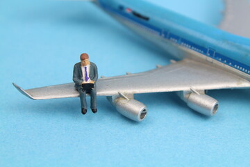 kleines Flugzeugmodell mit eine Figur eines Geschäftsmannes 