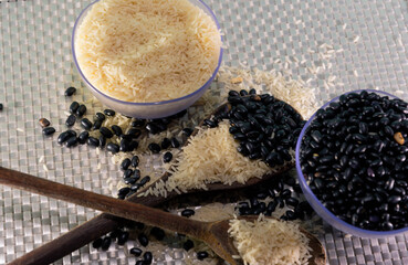 Rice and bean grains served in small bowls. Wooden scoop with beans and rice on a white background.