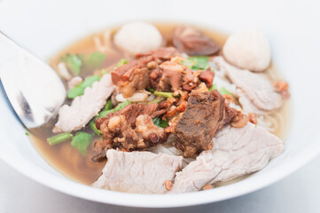 Braised beef noodles with meat balls in a white bowl