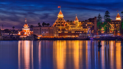Historic hotel decorated with holiday lights during Christmas with reflections in the water