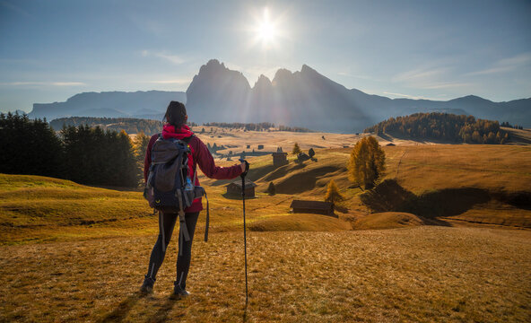A beautiful woman is standing in Alpe di suisi looking to the mountains