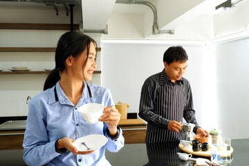 Beautiful Asian girl waiting for boyfriend to make coffee with happiness and happy to drink coffee feel chill morning.