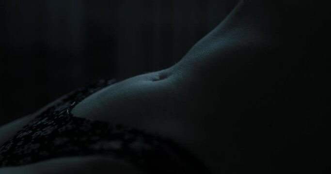 Sexy slim female belly in the dark