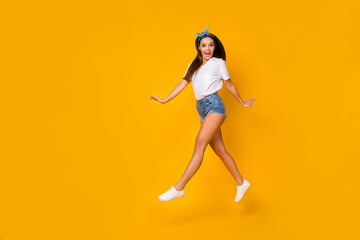 Fototapeta na wymiar Full body photo of excited crazy carefree youth girl jump enjoy spring free time holiday wear white blue headband isolated over bright color background