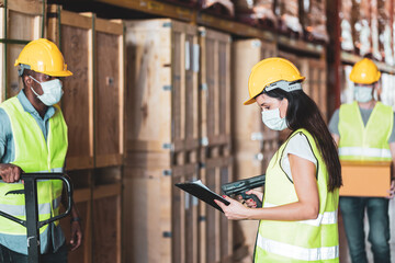 Diversity workers wear protective face mask in warehouse