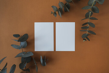 Blank paper sheet cards with empty copy space, dry eucalyptus branch on deep red background. Flat...