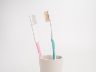 Bad breath concept. New toothbrush woman avoiding bad smell from the old dirty toothbrush man. Pastel toothbrushes on white background.  