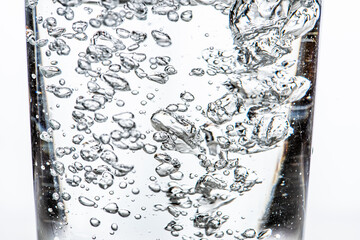 Water being poured into a glass. White background.