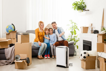 Fototapeta na wymiar air purifier in living room with happy family moving to new apartment
