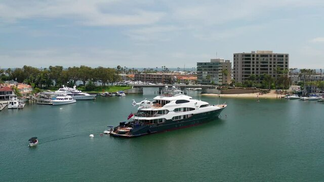 Aerial view of a wealthy billionaire luxury super yacht or mega-yacht docked in the harbor on a sunny day.	
