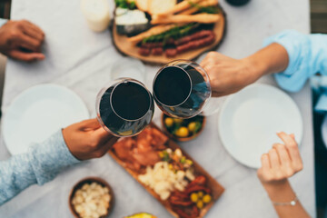 Couple in love making cheers with red wine glasses celebrating anniversary at home with healthy food, Romantic young couple having date dinner at outdoor restaurant terrace, Drinks Food Celebrate