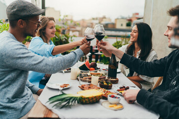 Group of happy people celebrating outdoors, Multiethnic group of young positive friends dining together on the rooftop or restaurant terrace celebrating, Summer Party Outdoors, Friendship Hanging Out