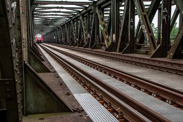 Fototapeta na wymiar A red german train crossing a bridge