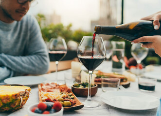 Young couple in love having romantic date celebrating anniversary at restaurant terrace, Friends having rooftop dinner party drinking wine enjoying food, happy friends eating healthy food at cafe