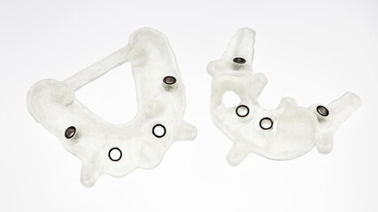 surgical dental implant templates for four implants for the lower and upper jaw, shot from above on a white background © Dental Pro Content