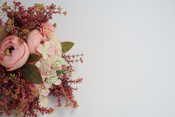 Green leaves with pink white flowers on white background.