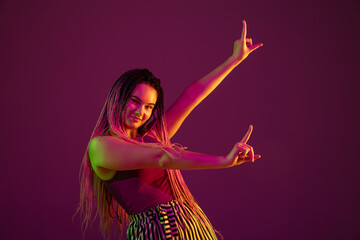 Young caucasian woman showing framing on pink studio background in neon light. Beautiful model with dreadlocks. Human emotions, facial expression, sales, ad concept. Freak's culture. Copyspace.