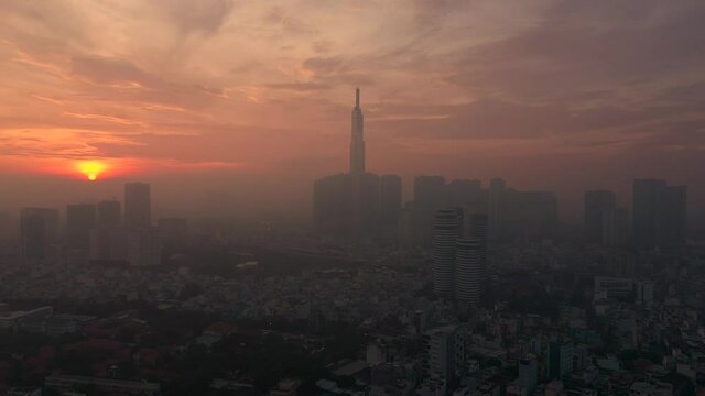 early morning urban aerial tracking shot with fog featuring sunrise, architecture river and dramatic sky