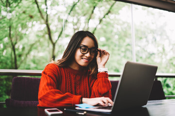 Smiling female copywriter satisfied with finishing online project working remotely on...