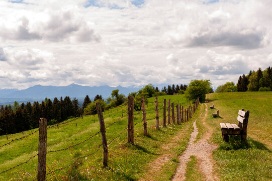 Ruheb&auml;nke am Wanderweg auf der Ilkah&ouml;he bei Tutzing, Oberbayern, auf die Alpenkette