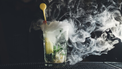 Close up shot of smoking cocktail on dark bar counter