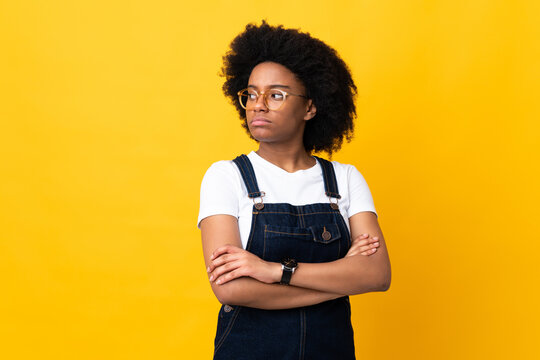 Young African American woman isolated on yellow background keeping the arms crossed