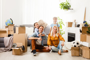 Happy family with cardboard boxes in new house at moving day.