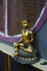 Obraz premium Closeup of golden buddha statue on wooden colorful background