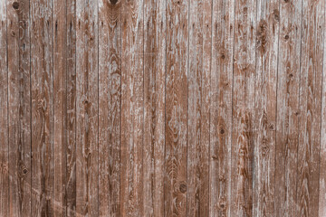 Old gray with shabby brown paint a wooden fence, aged background and texture. Rustic wooden fence plank. natural patterns background