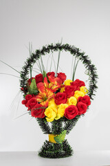 Basket with artificial flowers on a gray background
