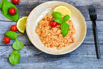Home made italian oven baked tomato risotto  with a fresh leaf of basil and parmesan cheese 