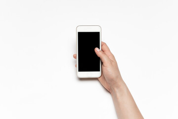 Close up of human hands using smartphone isolated on white background. Top view. Copyspace, blank screen. Surfing, online shopping, scrolling, betting, working. Education and business concept.