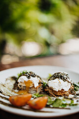 Photo of tasty poached with seeds, greens, tomatoes and sauce on white plate on blurred background