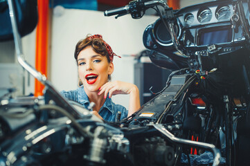 Plakat beautiful girl posing repairs a motorcycle in a workshop, pin-up style, service and sale