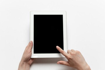 Close up of human hands using tablet isolated on white background. Top view. Copyspace, blank screen. Surfing, online shopping, scrolling, betting, working. Education and business concept.