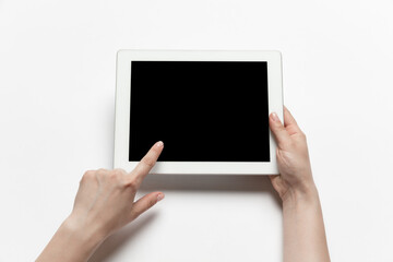 Close up of human hands using tablet isolated on white background. Top view. Copyspace, blank screen. Surfing, online shopping, scrolling, betting, working. Education and business concept.