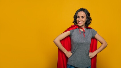 I am a superwoman! A young, beautiful girl, standing confidently with her fists on her waist,...