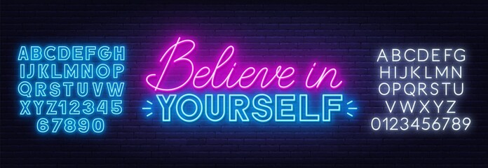 Believe in yourself neon quote on a brick wall. Inspirational glowing lettering. Neon alphabet on brick wall background.