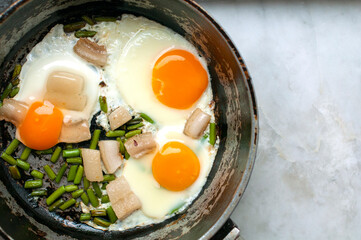 scrambled eggs with lard on a frying pan