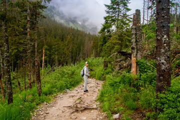 Fototapeta premium A man travels to the mountains. Hiking. High mountains in summer on a rainy day. Тatras.