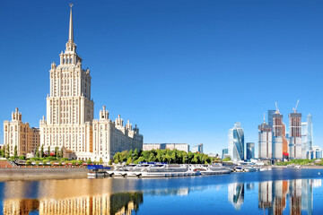 picturesque moscow city skyline landmark against blue sky background. Cityscape of russian capital. Old and new skyscrapers reflection on water of moscow river. Pleasure boats moored to embankment