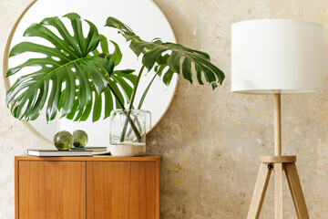 Beautiful composition at modern retro interior with design commode, tropical leaf in vase, round...