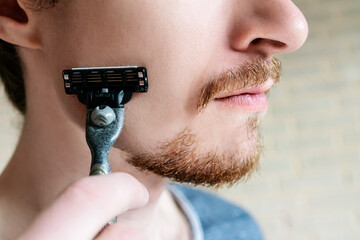 Young man with beard and shaver close up.