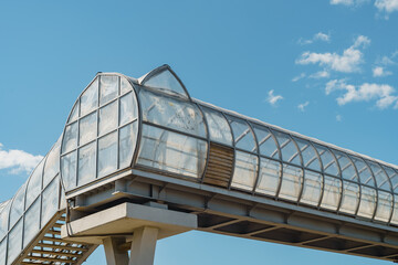 elevated pedestrian crossing over the freeway, white carbon fiber, arched tunnel, abstract background. High quality photo