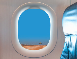 Airport Traffic Concept - Passenger airplane landing to airport seen through window of an aircraft