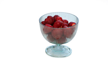 Strawberries in a transparent vase on a white background.