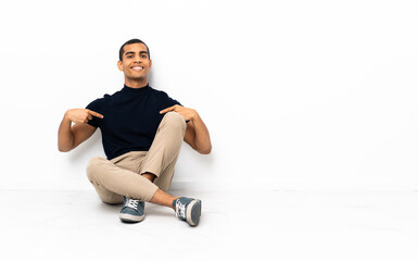 African American man sitting on the floor proud and self-satisfied