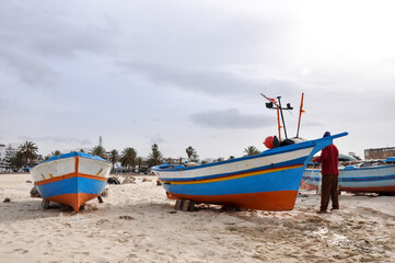 Naklejka na ściany i meble Hammamet, Tunisia- February 07, 2009: Tunisian Fishing boats on the beach with traditional colors.