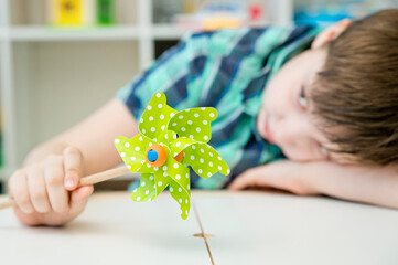 Boy playing with windmill at home
