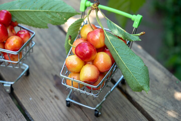 fresh ripe cherries in a shopping cart, fruits and berries purchasing concept